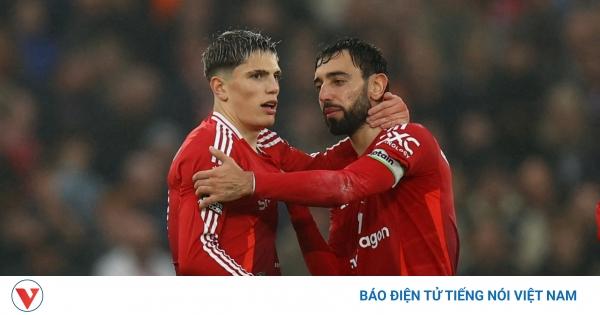 Góc khán đài Stretford End tại sân Old Trafford rực đỏ với cờ và biểu ngữ cổ vũ Manchester United